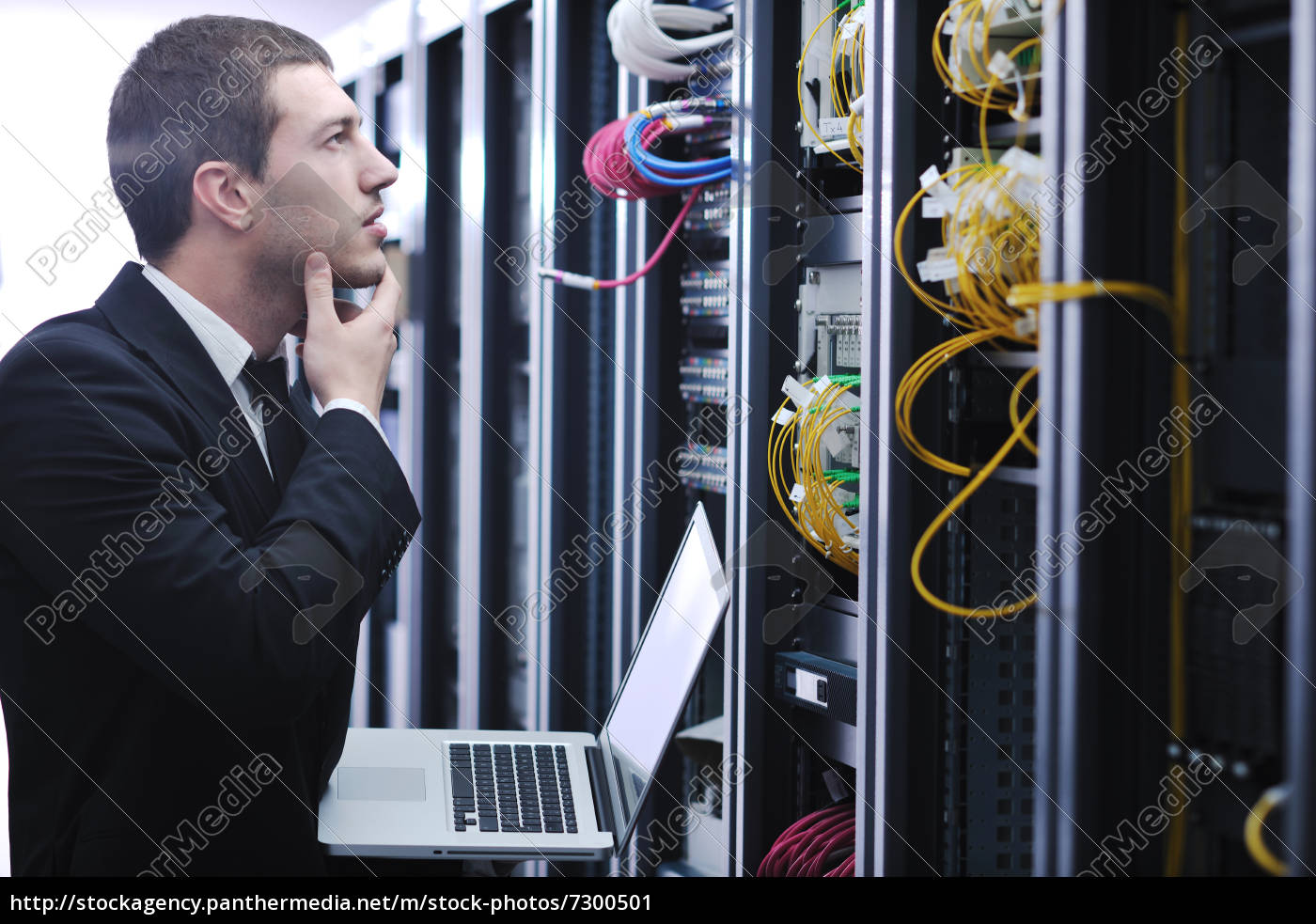 Geschäftsmann mit Laptop im Netzwerk Serverraum Lizenzfreies Bild