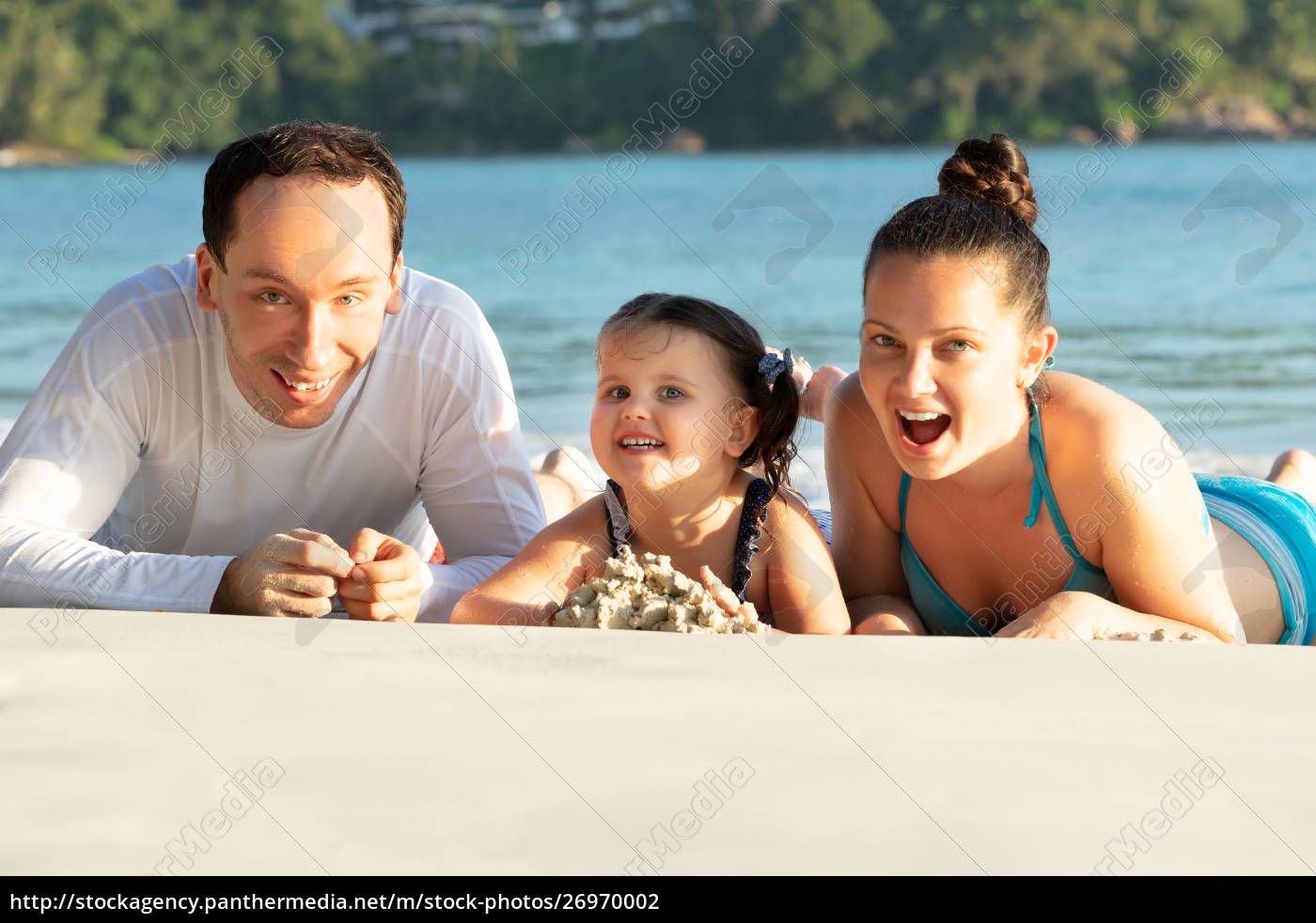 Glückliche junge Familie liegt am Sandstrand Stock Photo 26970002