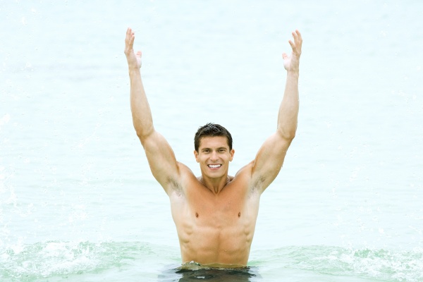 muskuloeser mann steht im schwimmbad mit