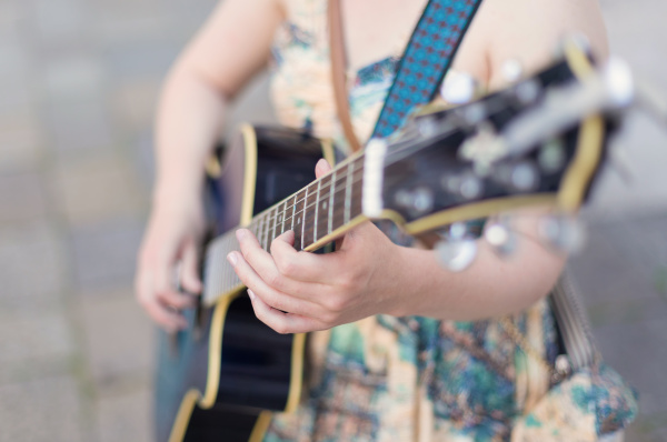 weibliche strassenmusiker gitarre zu spielen