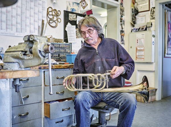 instrumentenmacher reparieren trompete in werkstatt