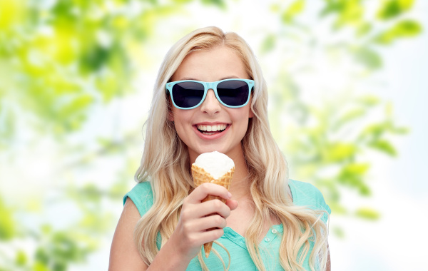 glueckliche junge frau mit sonnenbrille eis