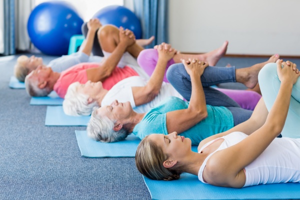 lehrer der yoga mit senioren ausfuehrt