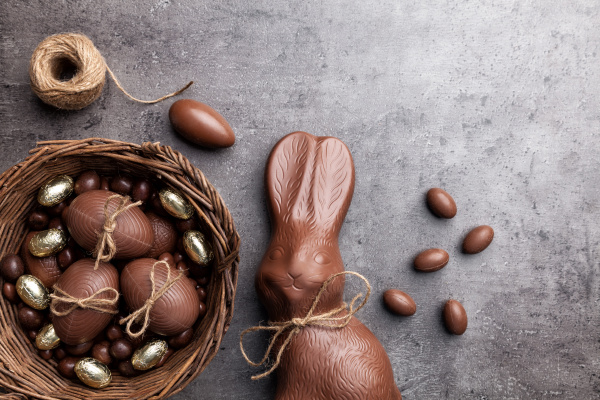 schokoladen osterhase und eier auf hoelzernem