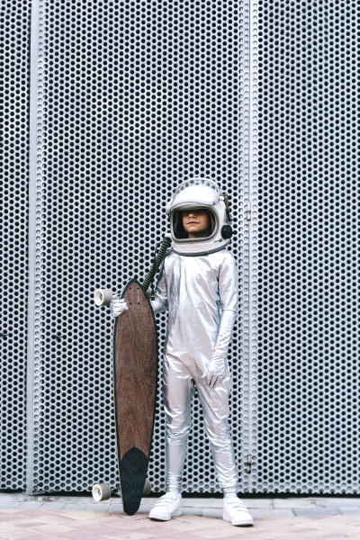 kind als astronaut mit longboard verkleidet