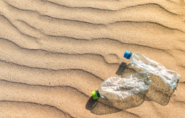 plastikflaschen auf dem sand am strand