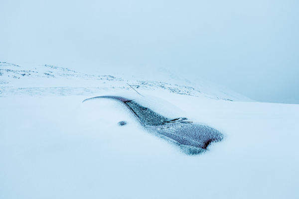 verschneites auto im winter norwegen