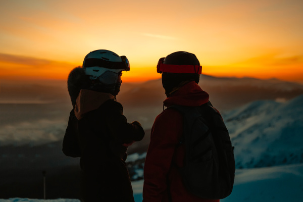 silhouette von zwei personen mit skihelmen