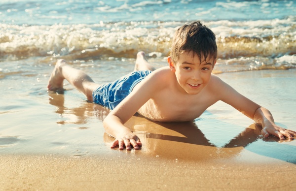 kind am strand liegend mit bademaske