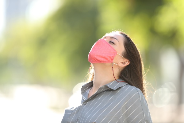frau traegt maske atmen frische luft