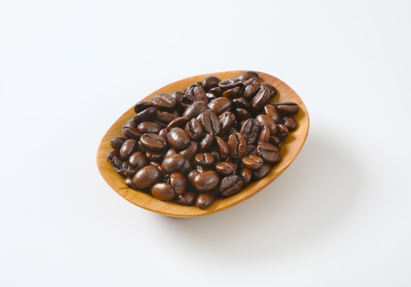 geroestete kaffeebohnen in holzschuessel