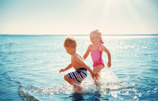 junge und maedchen spielen am strand