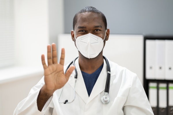 afroamerikanische mann arzt traegt medizinische maske