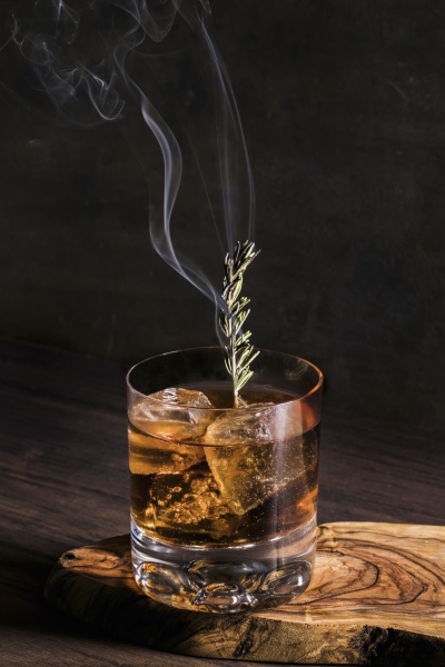 altmodischer cocktail mit eiswuerfeln und rauchendem