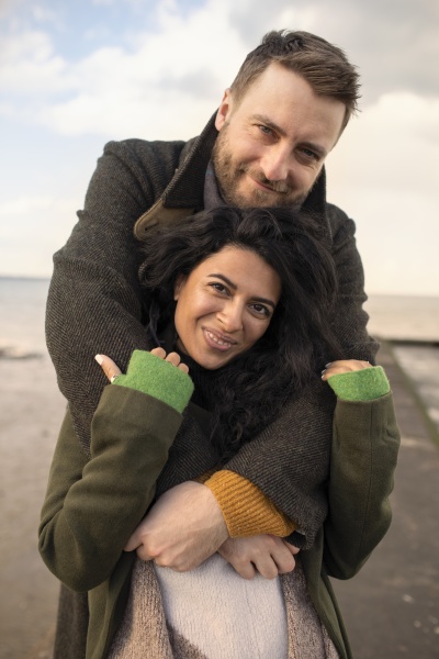 portraet glueckliches paar in wintermaenteln umarmt