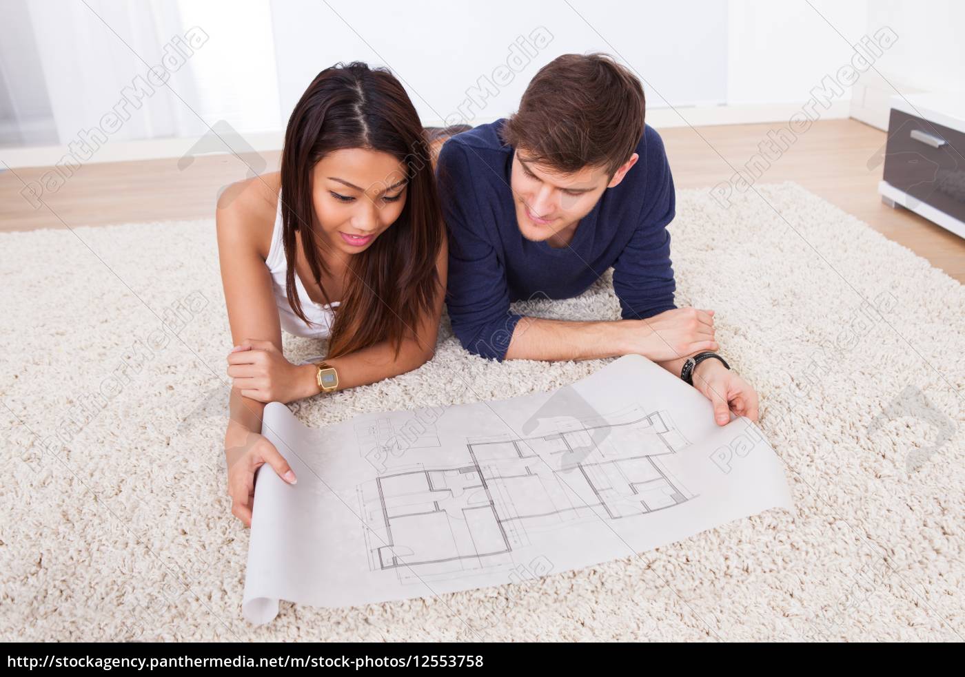 couple-looking-at-blueprint-while-sitting-on-rug-stockfoto-12553758-bildagentur-panthermedia