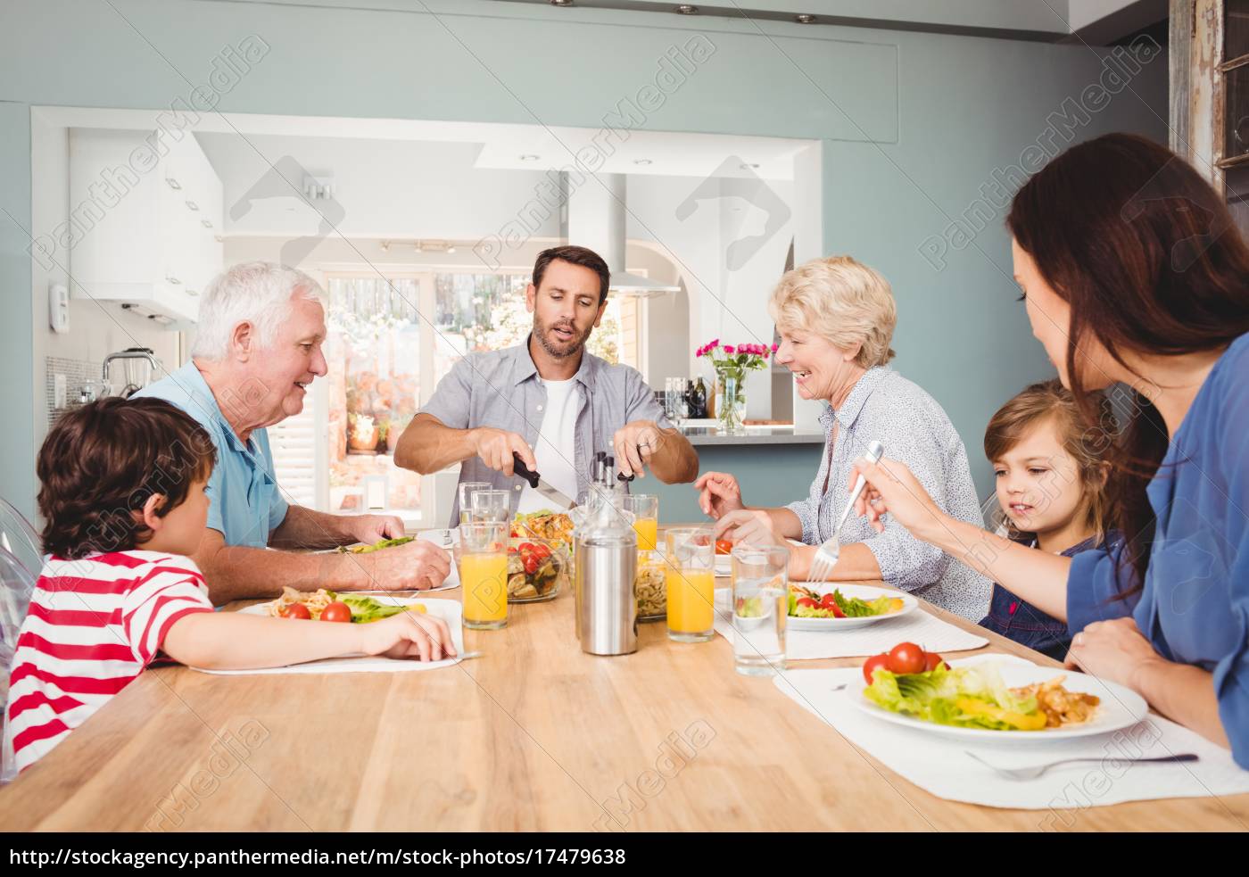 Gluckliche Familie Mit Grosseltern Am Esstisch Sitzen Stockfoto Bildagentur Panthermedia