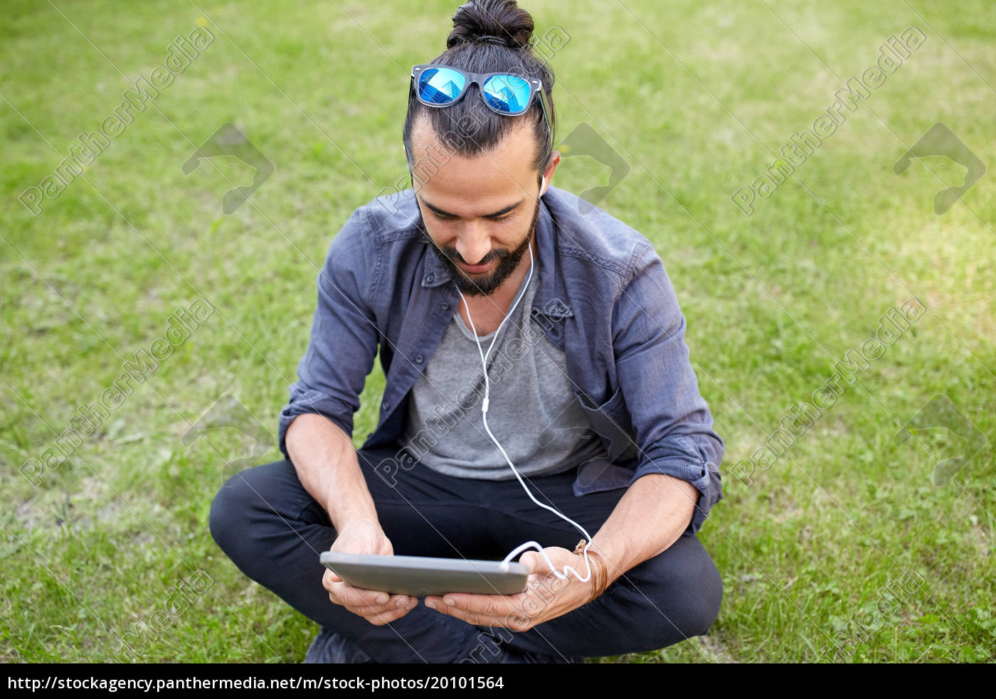 Mann Mit Kopfhörern Und Smartphone Auf Gras Sitzend Lizenzfreies Foto 20101564